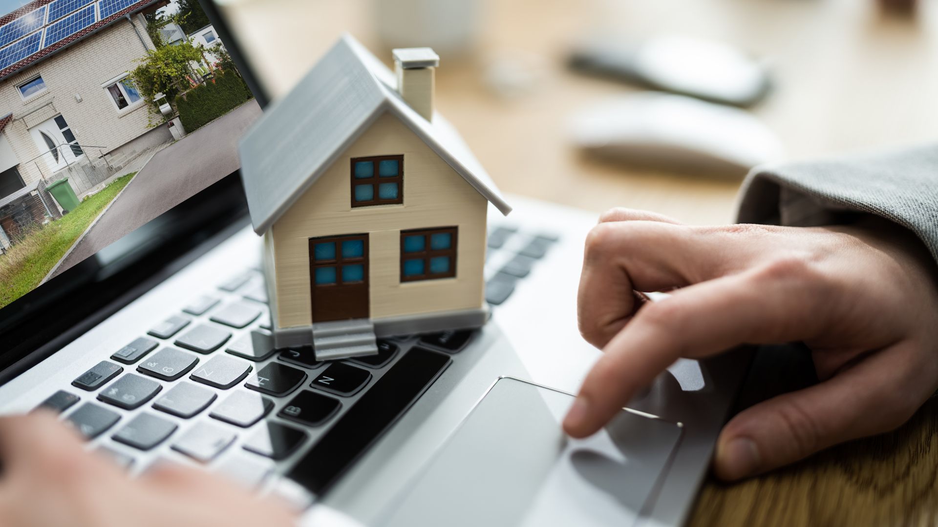 A person using a laptop with a house on the screen