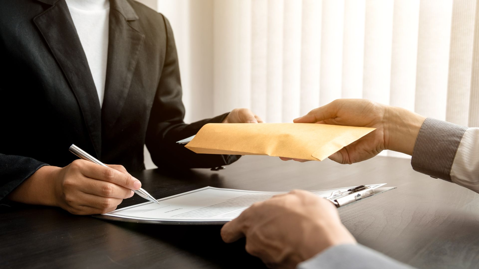 A person handing another person a piece of paper