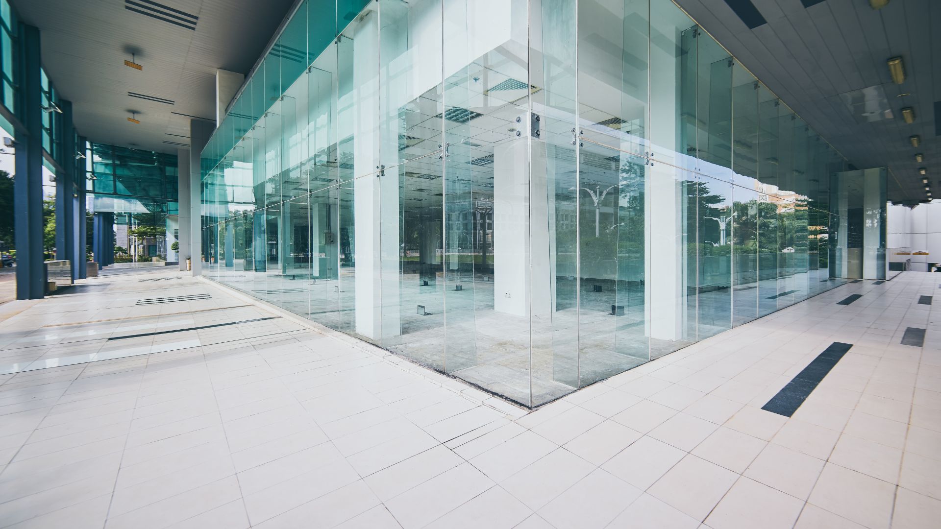 A large glass building with a white tiled floor